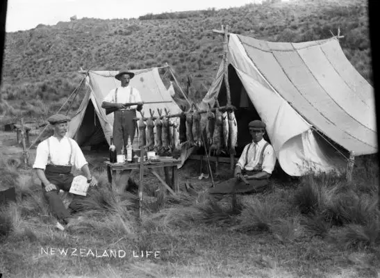 Men at their campsite displaying their catch of rabbits and fish (1909). Image credit: National Library (via Wikimedia Commons).